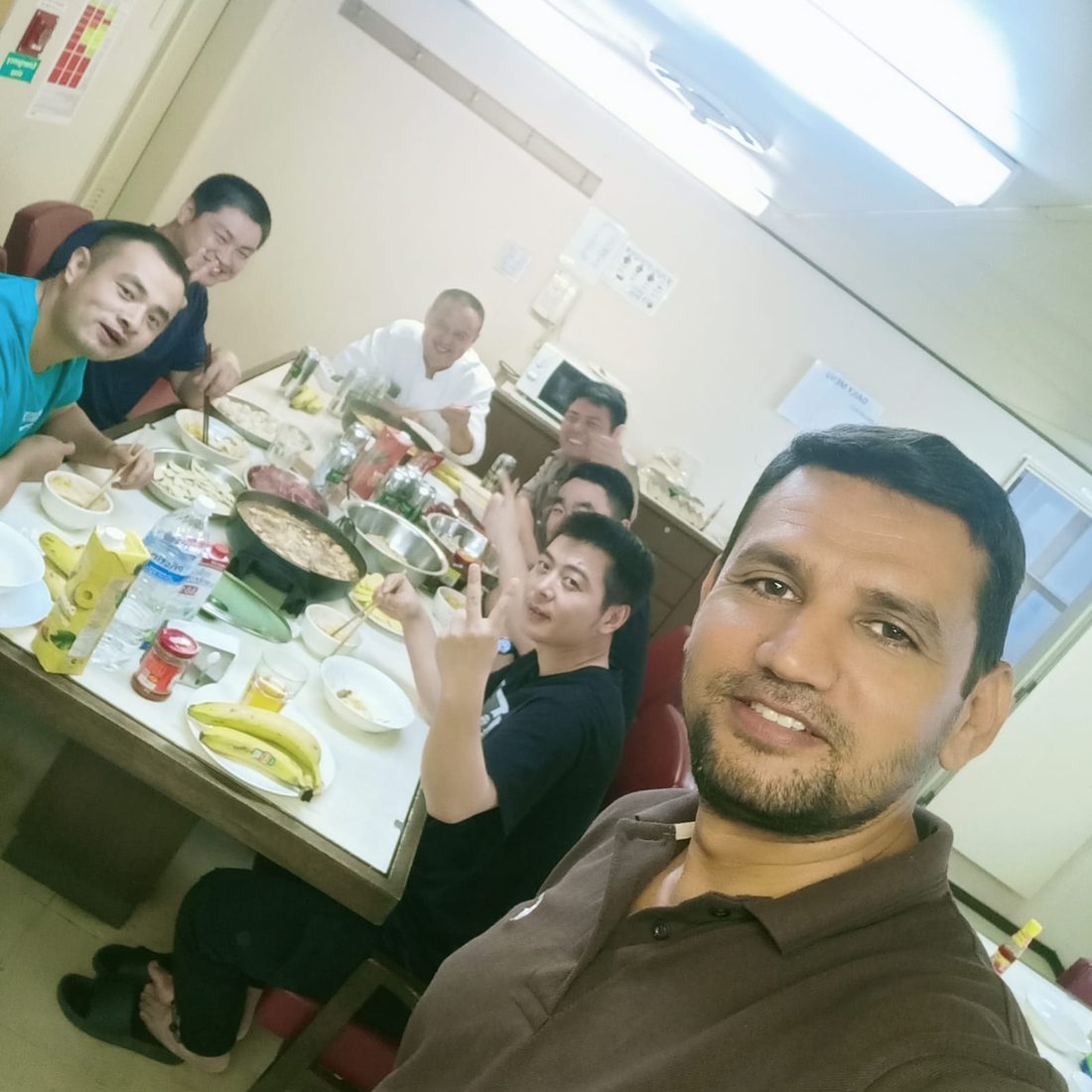 Marvell Agencies crew sharing a meal with multinational crewmates aboard ship